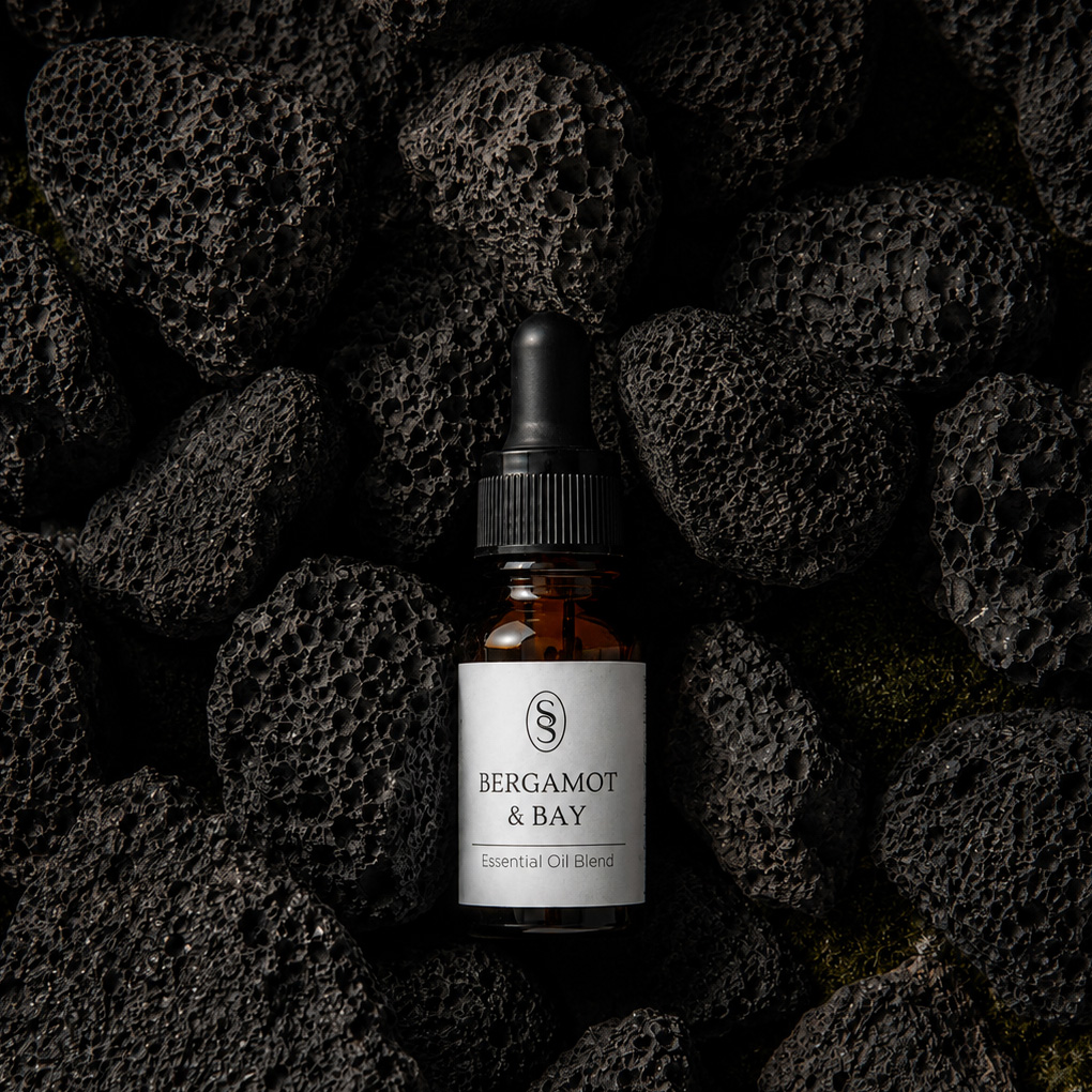 Bergamot & Bay pure essential oil blend bottle resting on natural lava stones