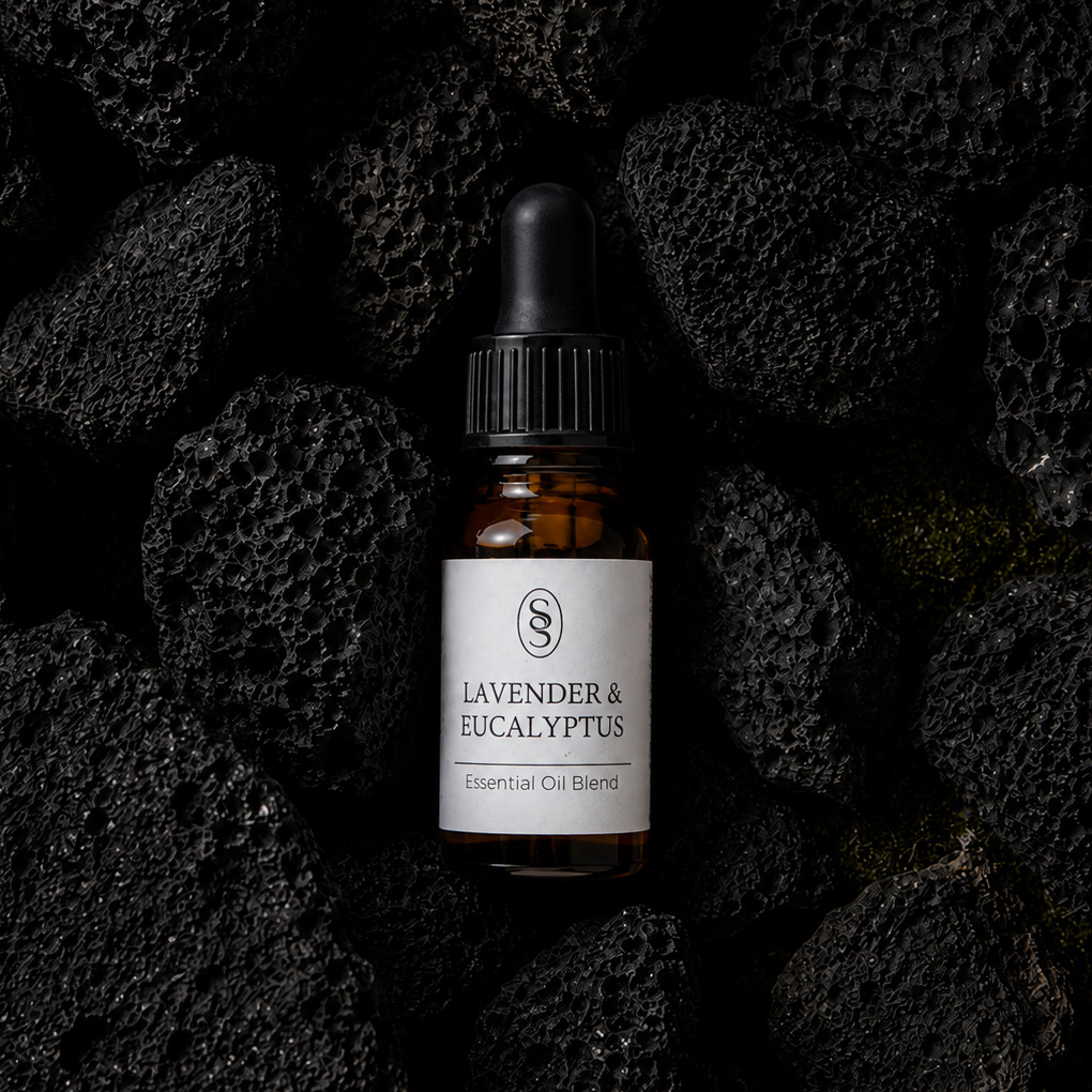 Lavender & Eucalyptus pure essential oil blend bottle resting on natural lava stones