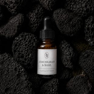 Lemongrass & Basil pure essential oil blend bottle resting on natural lava stones