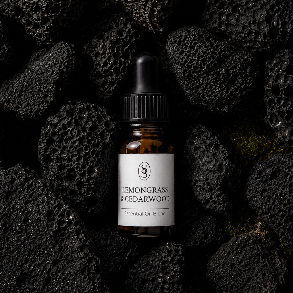 Lemongrass & Cedarwood pure essential oil blend bottle resting on natural lava stones