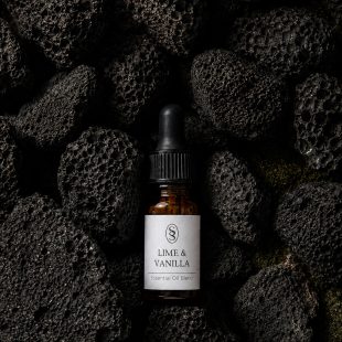 Lime & Vanilla pure essential oil blend bottle resting on natural lava stones