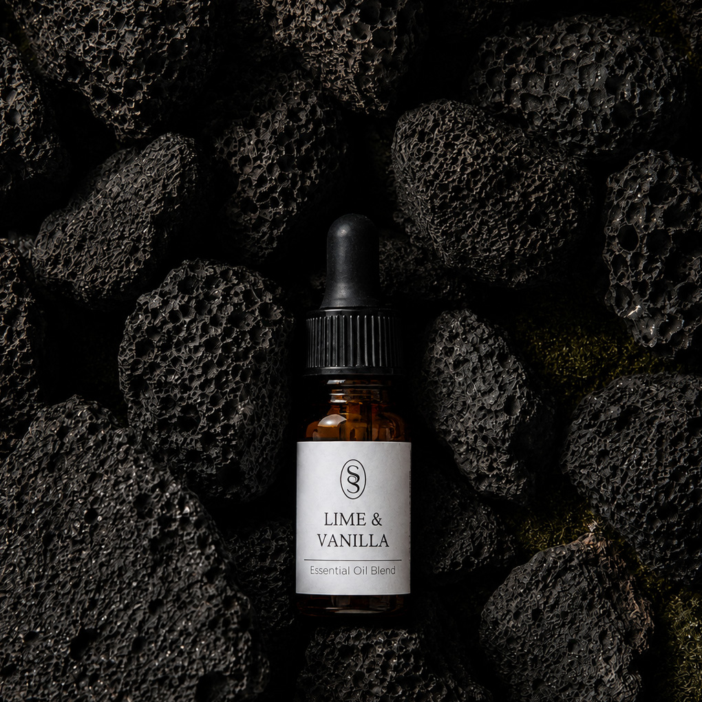 Lime & Vanilla pure essential oil blend bottle resting on natural lava stones
