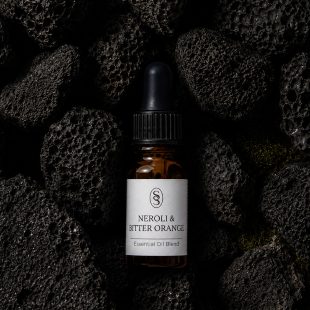 Neroli & Bitter Orange pure essential oil blend bottle resting on natural lava stones