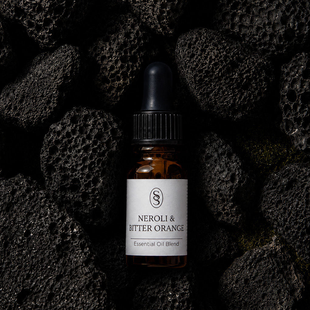 Neroli & Bitter Orange pure essential oil blend bottle resting on natural lava stones